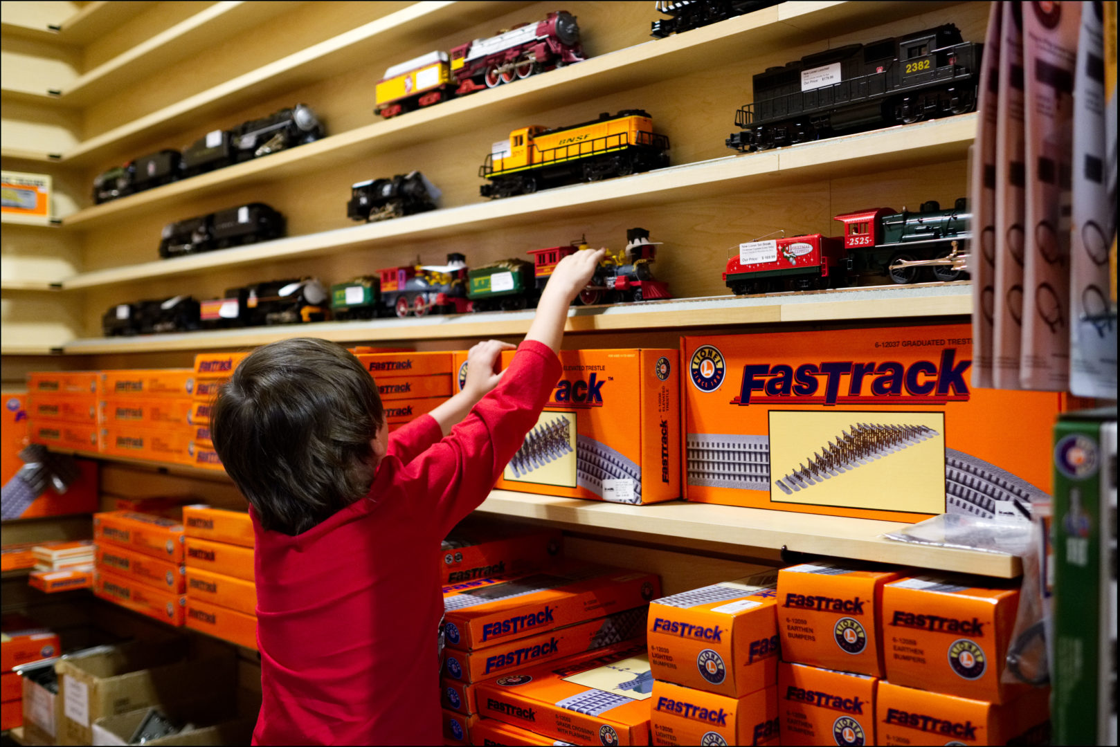 A boy chooses a model train from the display wall.