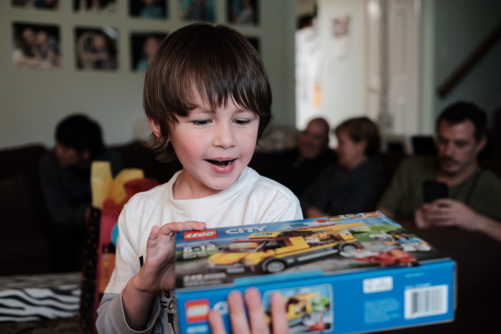 A happy boy looks at his LEGO box