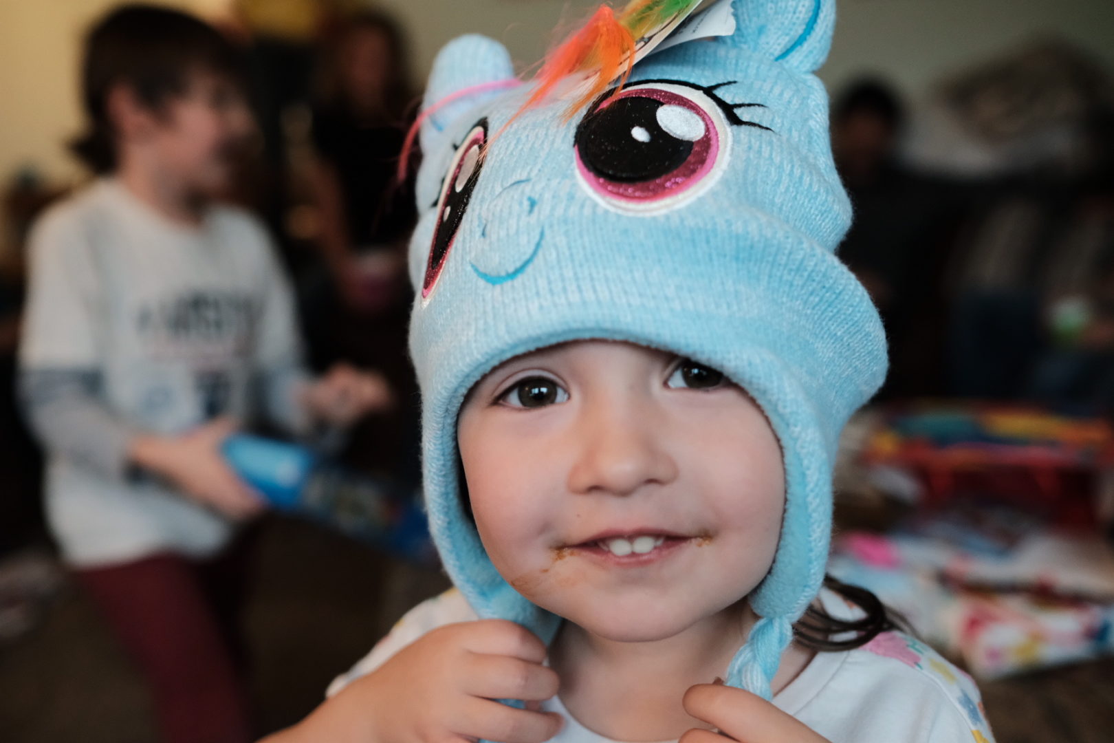 A little girl wearing a My Little Pony hat