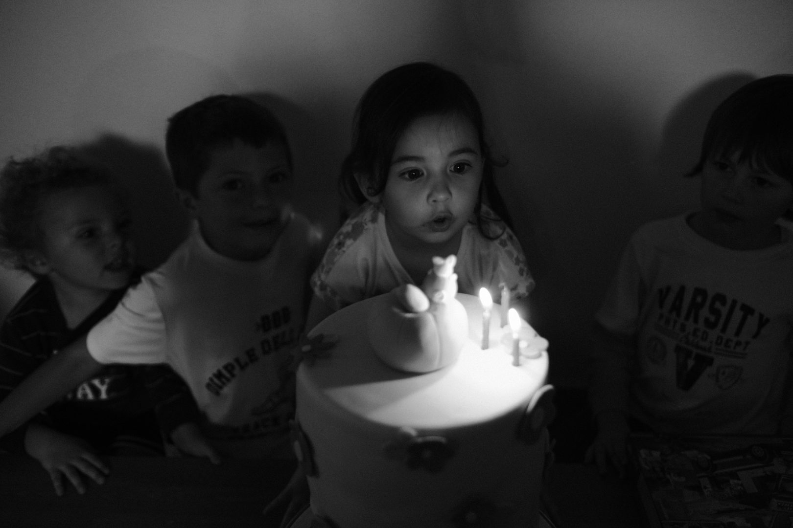 A little girl blows out the candles on her birthday cake