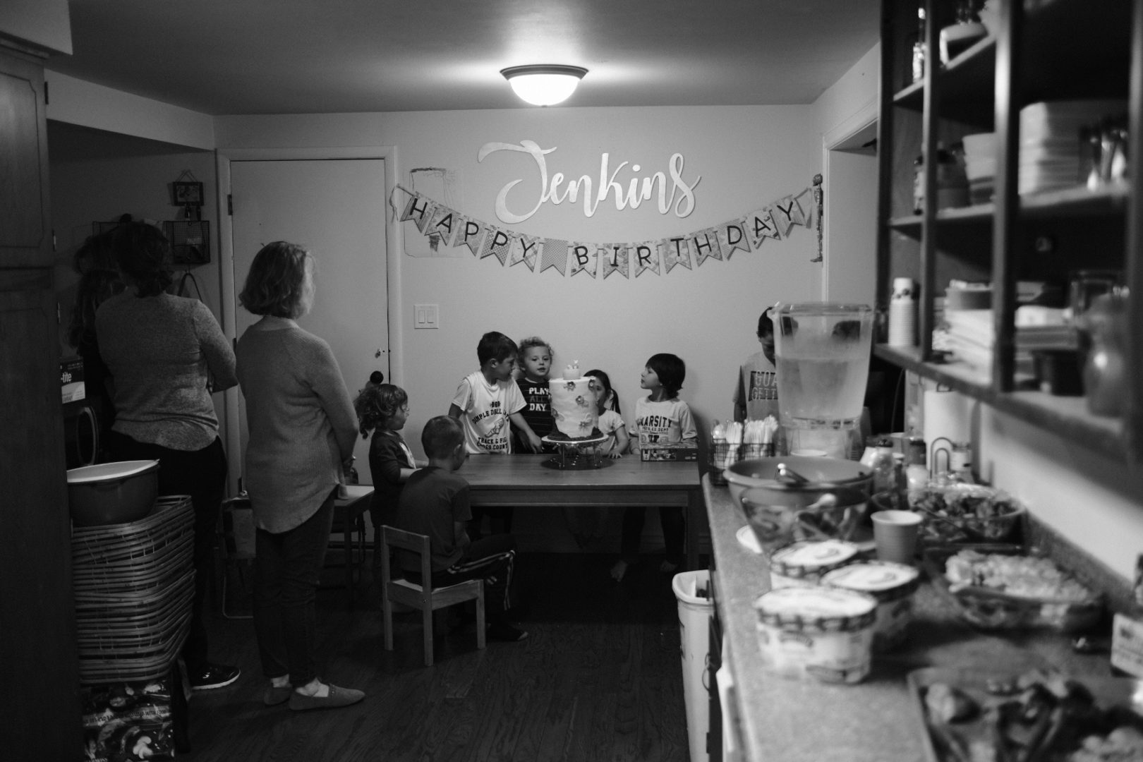 A black and white scene of a birthday party