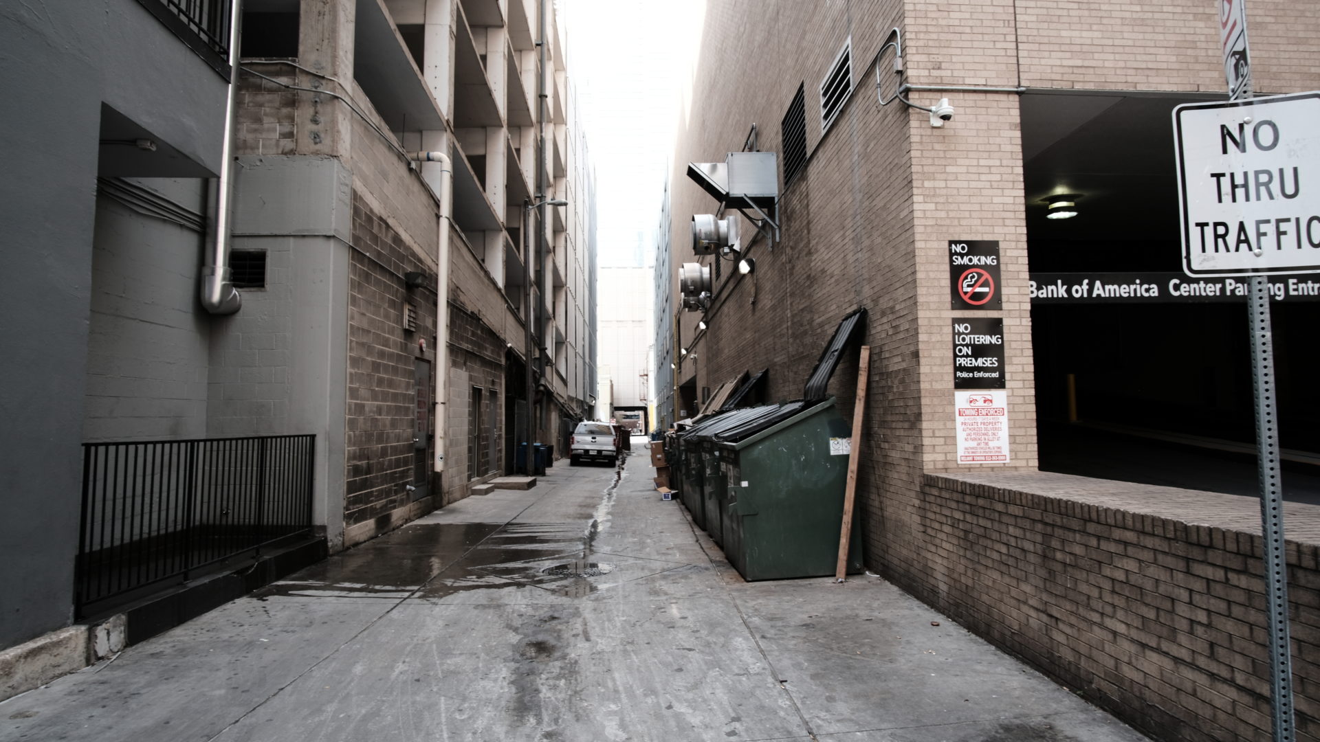 An alley lined with garbage dumpsters in Austin, Texas